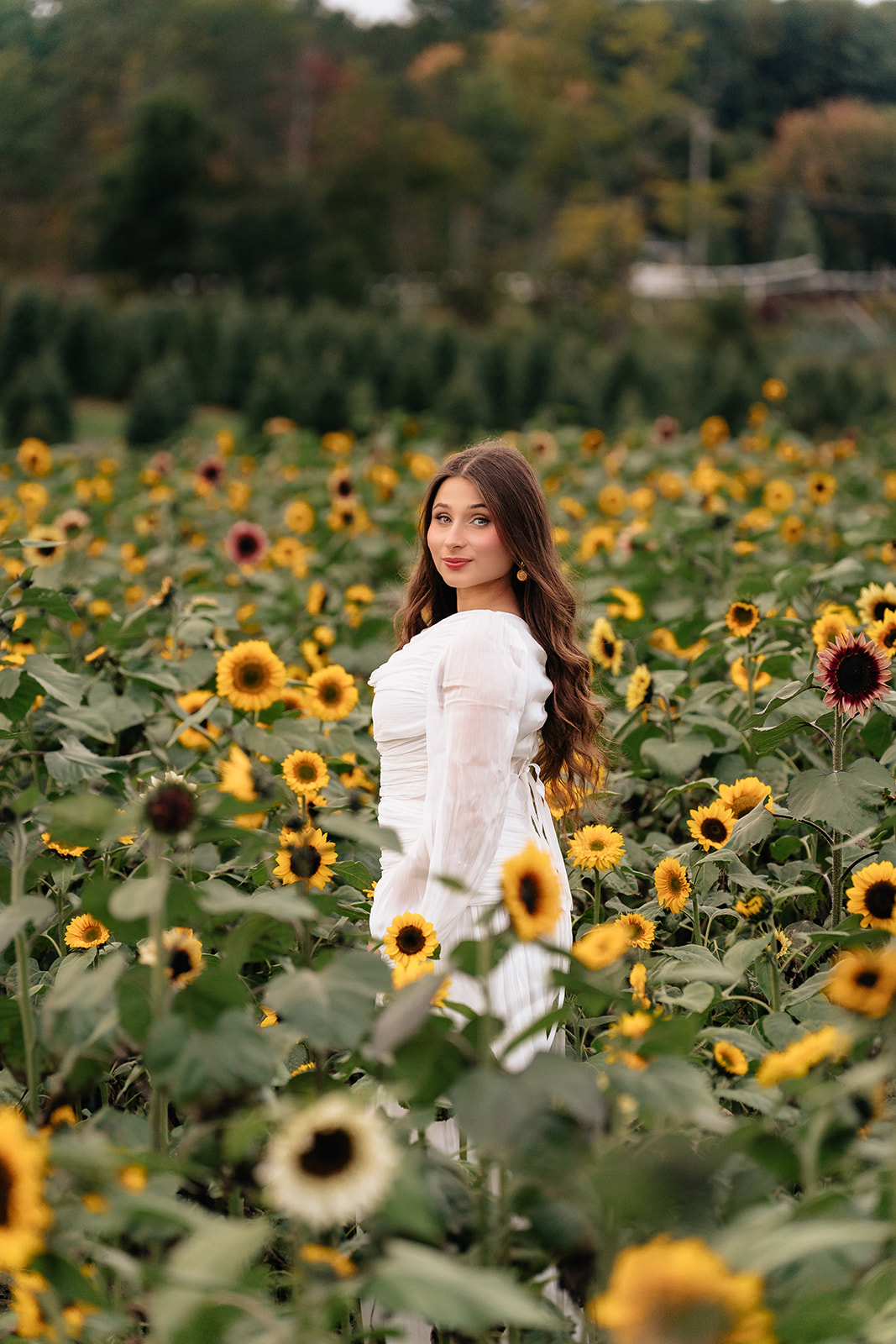 Solo portrait of Suemaya standing among rows of sunflowers at Rogish Farm