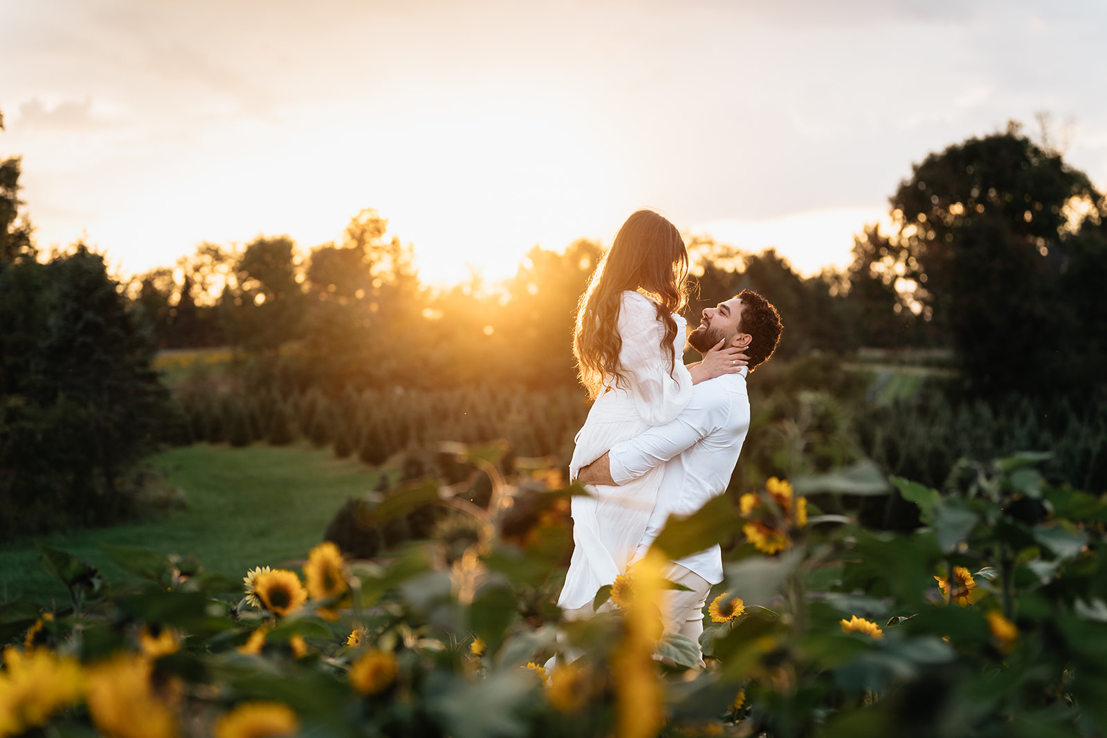 Suemaya leaning over Assad's shoulder in a playful lift against the sunset at Rogish Farm