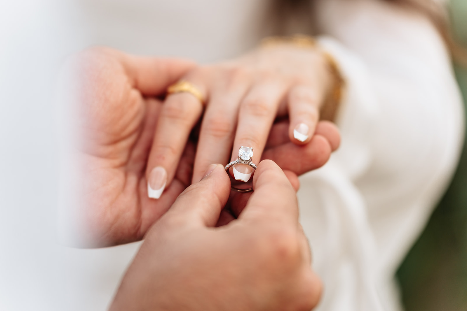 Close detail of Suemaya's ring and the couple's hands during their sunflower-field session