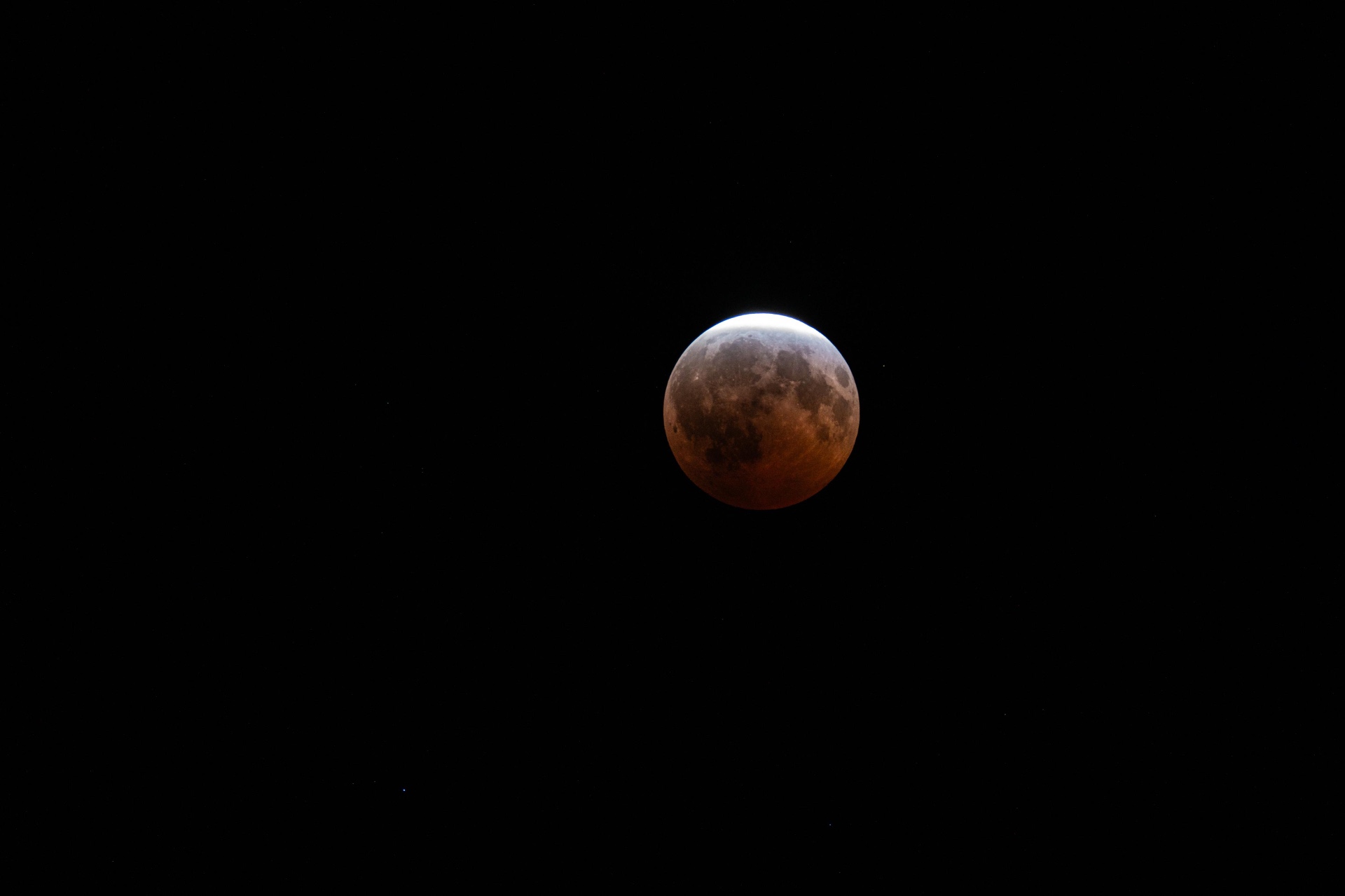 Wide frame of the August 2026 deep partial lunar eclipse against a black Northeast Ohio sky, photographed by Rada Abib Photography